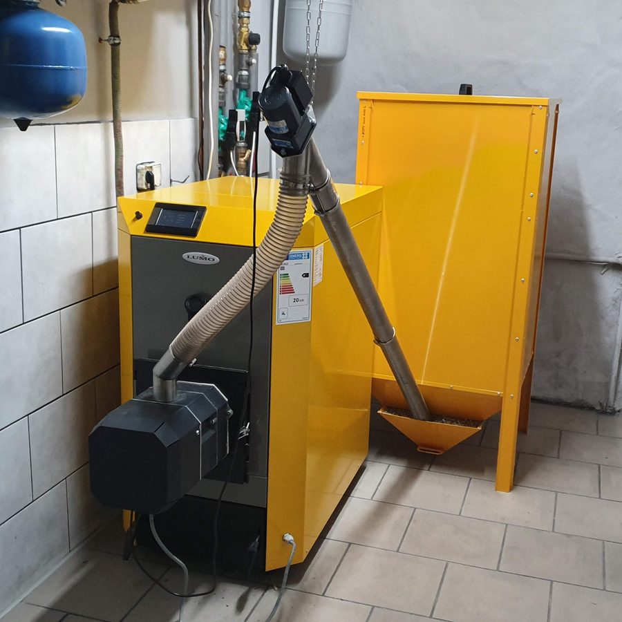 Piec z palnikiem na pellet i zasobnikiem w kotłowni w Mroczy